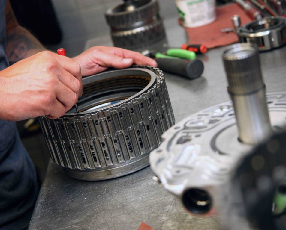 Photo transmission specialists working on the transmission drum, where band adjustment service would occur