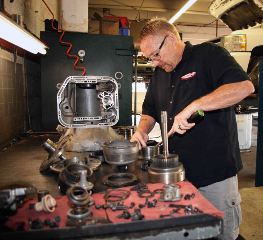 Photo of Michael, owner and transmission specialist at our shop, working on auto parts